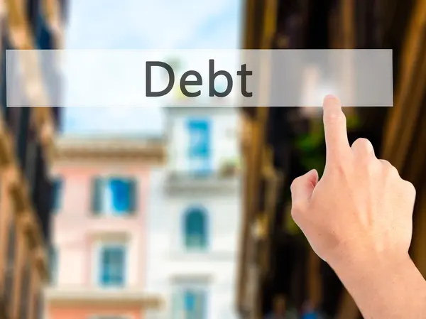 Debt - Hand pressing a button on blurred background concept on v — Stock Photo, Image