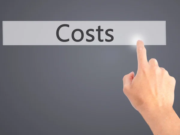 Kosten - Hand indrukken van een knop op onscherpe achtergrond concept op — Stockfoto
