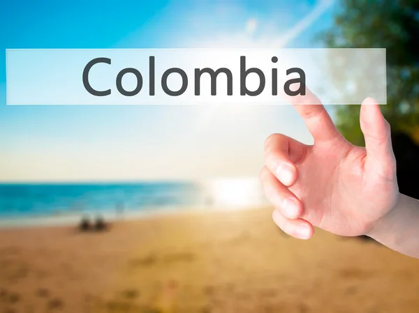 Colombia - Hand pressing a button on blurred background concept — Stock Photo, Image