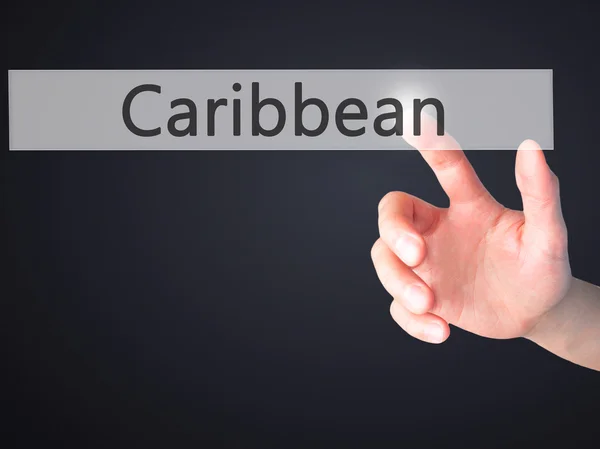 Caribbean - Hand pressing a button on blurred background concept — Stock Photo, Image