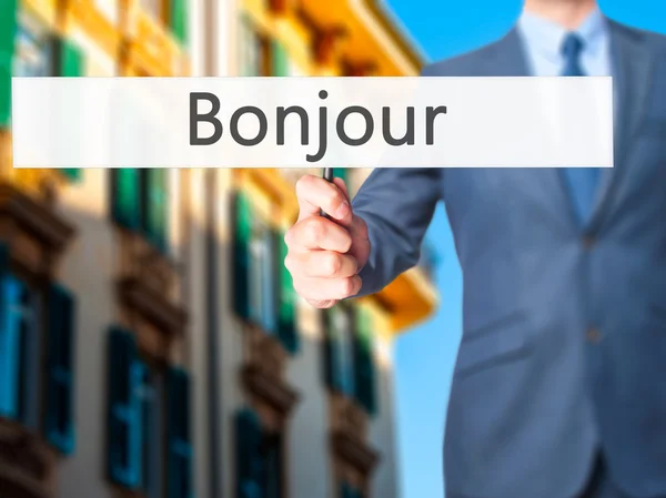 Bonjour (Bom dia em francês) - Empresário mão segurando sinal — Fotografia de Stock