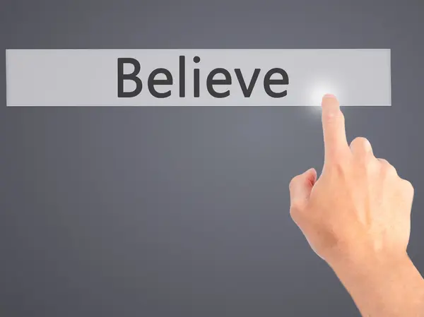 Believe - Hand pressing a button on blurred background concept o — Stock Photo, Image