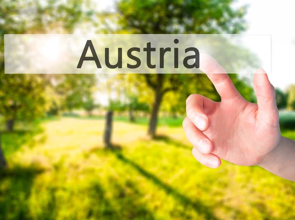 Österrike - Hand trycka på en knapp på suddig bakgrund koncept o — Stockfoto
