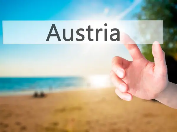 Austria - Hand pressing a button on blurred background concept o — Stock Photo, Image