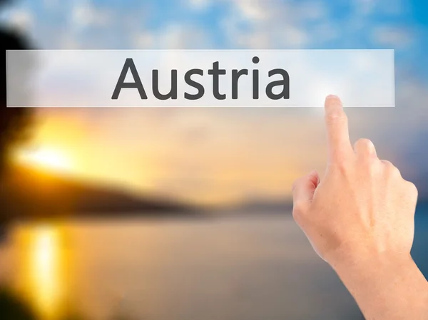 Österreich - Hand auf Knopfdruck auf verschwommenes Hintergrundkonzept o — Stockfoto