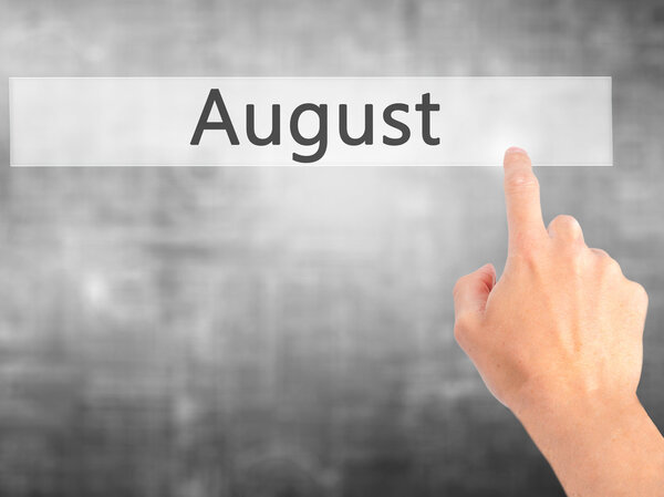 August - Hand pressing a button on blurred background concept on