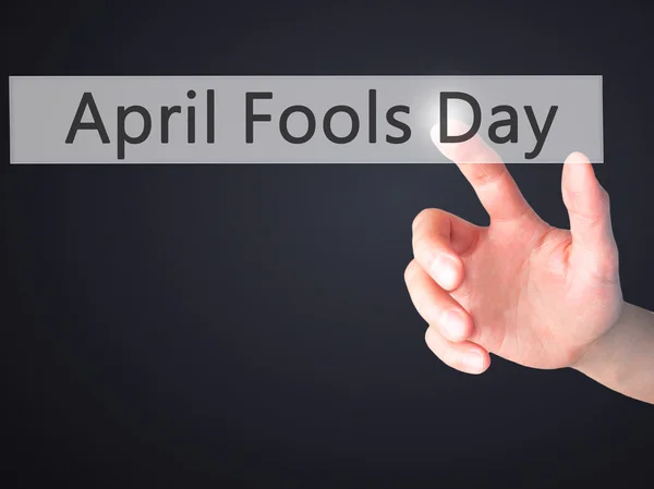 April Fools Day - Hand pressing a button on blurred background c — Stock Photo, Image