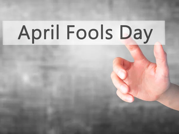 April Fools Day - Hand indrukken van een knop op de onscherpe achtergrond c — Stockfoto