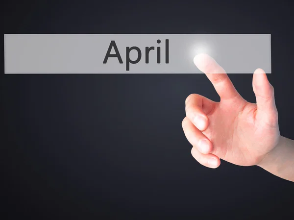 April - Hand pressing a button on blurred background concept on — Stock Photo, Image