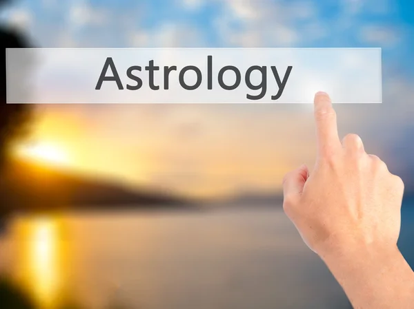 Astrologie - Hand indrukken van een knop op onscherpe achtergrond concept — Stockfoto