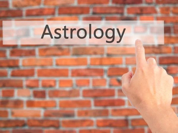 Astrologie - Hand indrukken van een knop op onscherpe achtergrond concept — Stockfoto