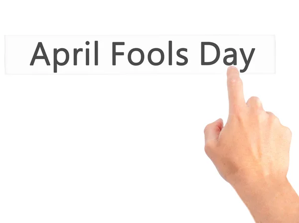 April Fools Day - Hand pressing a button on blurred background c — Stock Photo, Image