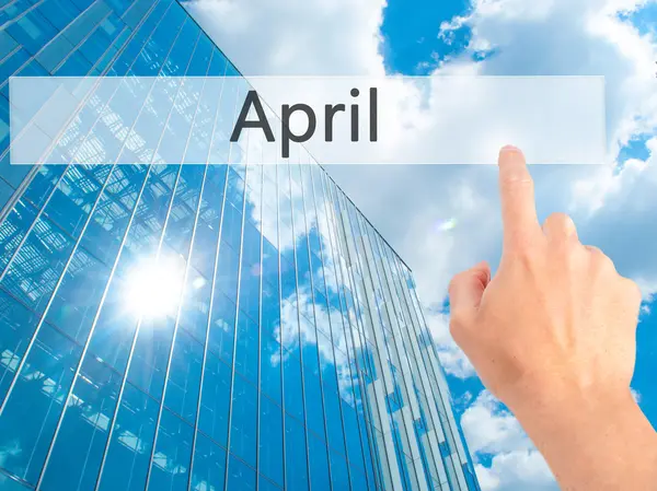 April - Hand indrukken van een knop op onscherpe achtergrond concept op — Stockfoto