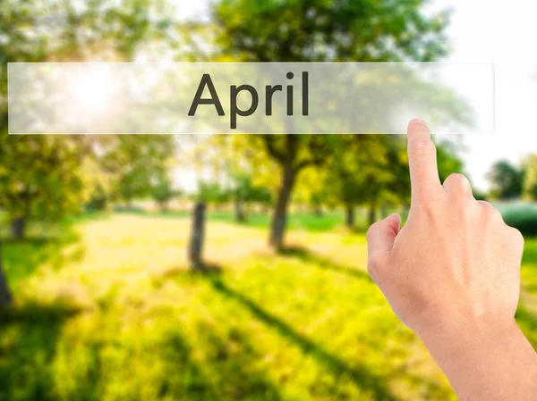 April - Hand pressing a button on blurred background concept on — Stock Photo, Image