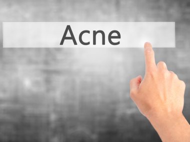 Akne - El v bulanık arka plan kavramı bir düğmeye basarak