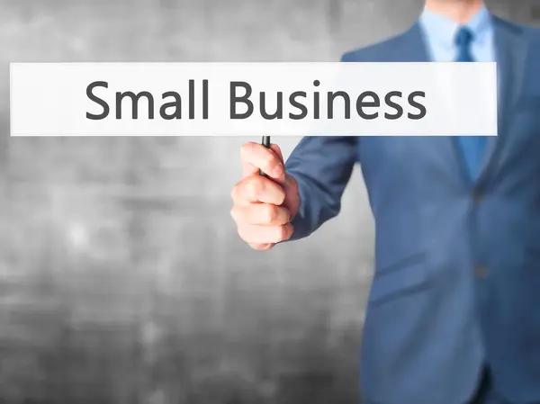 Kleine business-zakenman hand holding teken — Stockfoto