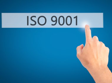 Iso 9001 - Bulanık arka plan konseptinde düğmeye basarak el 