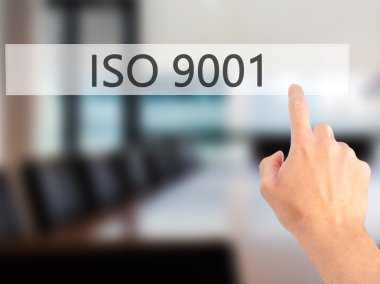 Iso 9001 - Bulanık arka plan konseptinde düğmeye basarak el 
