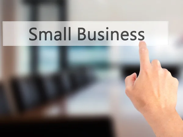 Small Business-met de hand een knop op onscherpe achtergrond samendrukken — Stockfoto