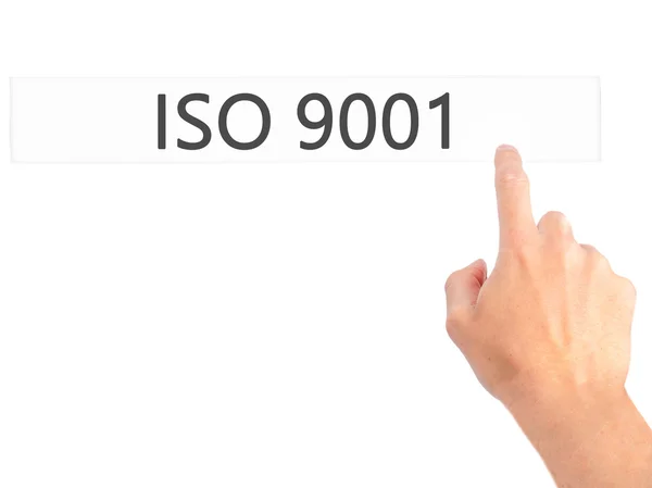 ISO 9001 - Ручное нажатие кнопки на размытом фоне концепции — стоковое фото