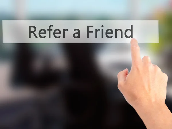 Refer a Friend - Hand pressing a button on blurred background co — Stock Photo, Image