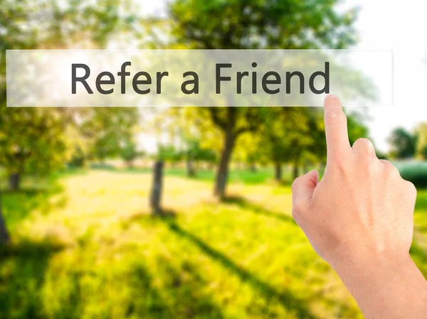 Refer a Friend - Hand pressing a button on blurred background co — Stock Photo, Image