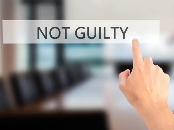 NOT GUILTY - Hand pressing a button on blurred background concep — Stock Photo, Image