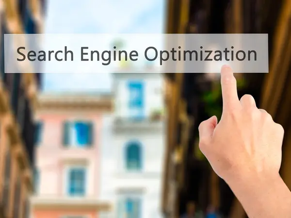 Optimización del motor de búsqueda - Mano presionando un botón en borrosa b — Foto de Stock