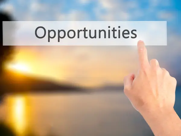 Opportunities-hand indrukken van een knop op onscherpe achtergrond con — Stockfoto