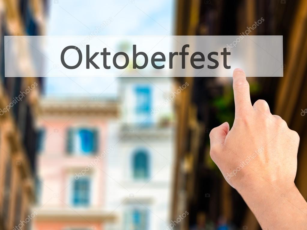 Oktoberfest - Hand pressing a button on blurred background conce