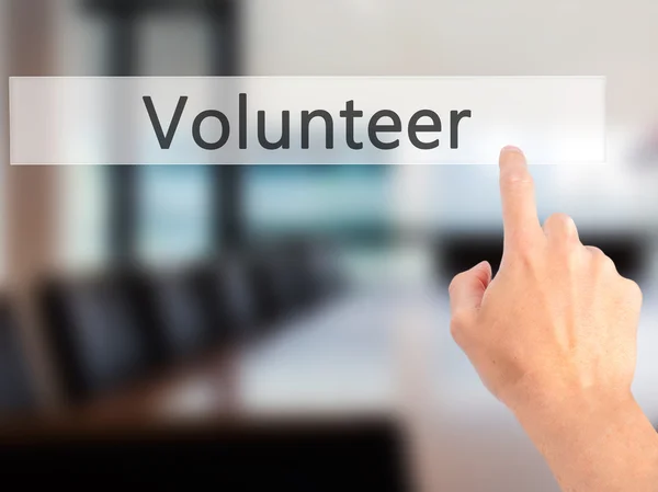 Voluntário - Mão pressionando um botão no conceito de fundo embaçado — Fotografia de Stock