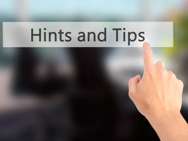 Hints and Tips - Hand pressing a button on blurred background co — Stock Photo, Image