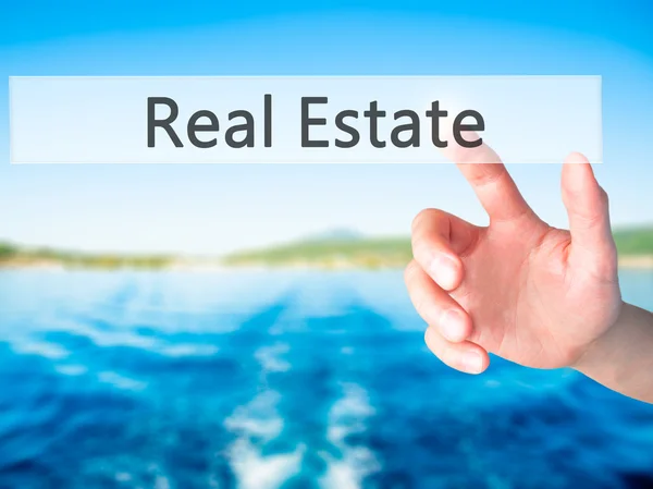 Real Estate-hand trycka på en knapp på suddig bakgrund conce — Stockfoto