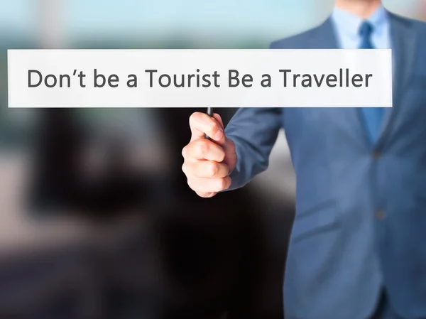 No seas un turista Sé un viajero - Empresario de la mano sosteniendo sig — Foto de Stock