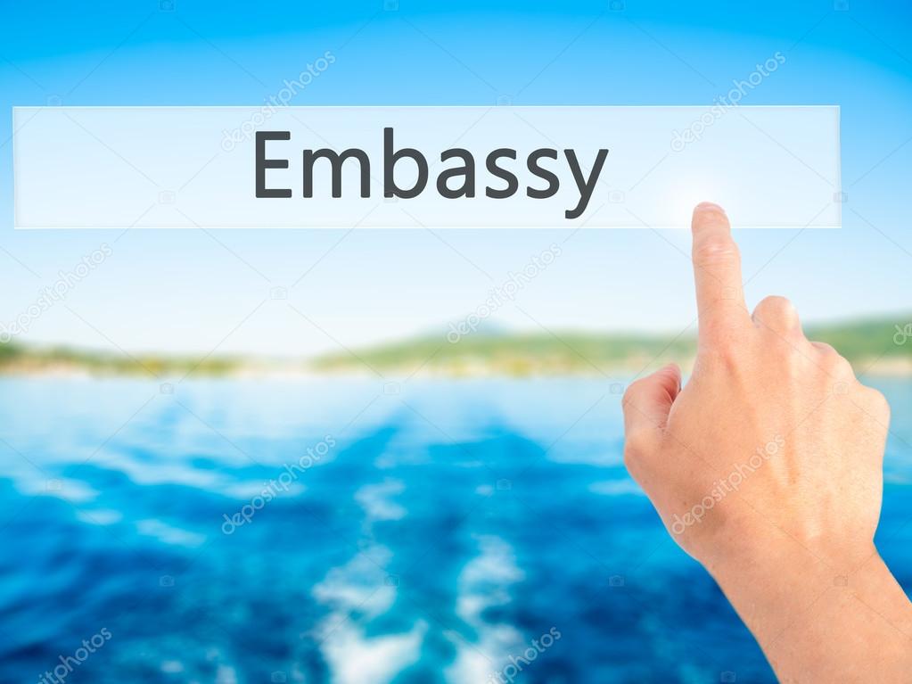 Embassy - Hand pressing a button on blurred background concept o