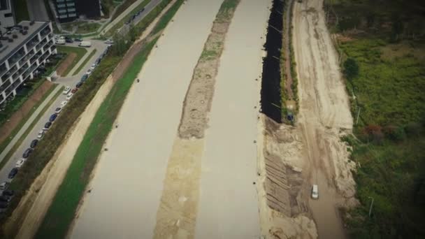 Vista aérea de obras de construção de uma seção de rodovia. Os carros vão de ambos os lados. O regime de circulação dos transportes mudou. A estrada atravessa as florestas e campos perto da aldeia — Vídeo de Stock