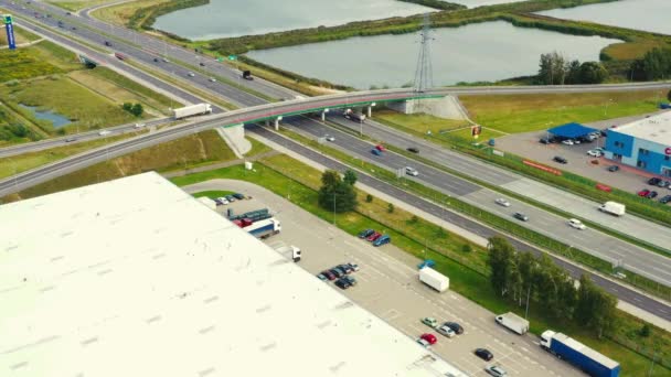 Luftaufnahme des Logistikzentrums, Lagerhallen in der Nähe der Autobahn. Verkehr — Stockvideo