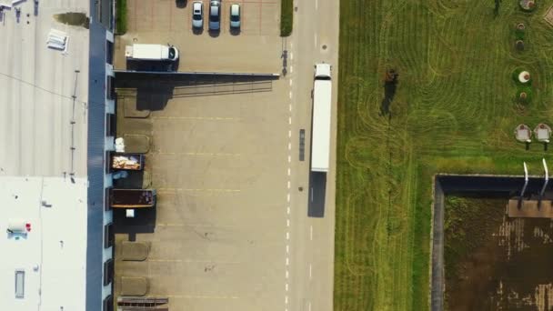 Logistikpark med ett lager - laddningsstation. Halvlastbilar med släpvagnar som står vid ramperna för lastning / lossning av gods. Flygplan — Stockvideo