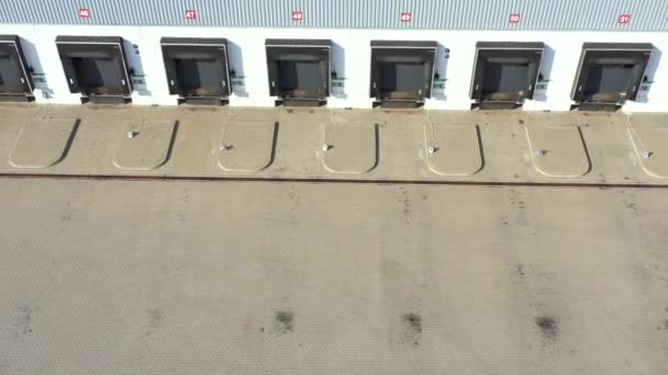 Parque de logística com armazéns, hub de carregamento e um monte de caminhões semi-reboque espera por carga e descarregar mercadorias em rampas. Vista aérea — Vídeo de Stock