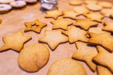 Ev yapımı zencefilli kurabiyeler (yıldızlar) kabartma kağıdı ve kırsal ahşap masa üzerinde