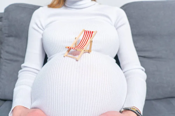 怀孕的女人在海滩上摸她的肚子假期的概念 — 图库照片