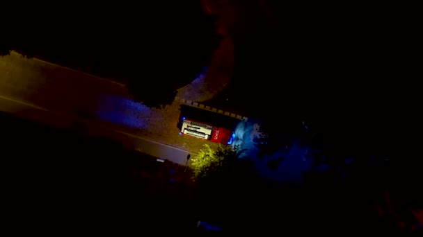 Fire truck with emergency lights on the small street at night time. Fire Engine at Scene of accident responds to emergency call. Aerial shot — Stock Video