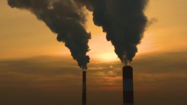 Elektrik santrali güneş doğarken şehrin üzerinde görüldü. Çevre kirliliği. Fabrika borusu hava kirletiyor. Panorama günbatımı. Sigara içilen borular Hava görüntüsü,