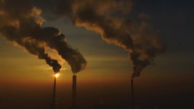 Elektrik santrali güneş doğarken şehrin üzerinde görüldü. Çevre kirliliği. Fabrika borusu hava kirletiyor. Panorama günbatımı. Sigara içilen borular Hava görüntüsü,