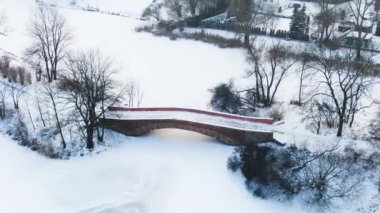 Kış panoraması. Donmuş ağaçlar, çalılar ve çayırlar. Kış sahnesi - Karlı parktaki eski köprü. Hava görünümü.