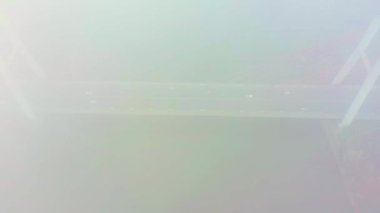 Hava aracı görüntüsü. Güneşli bir sabahta köprü. Havada sonbahar sisi var, arabalar köprüden geçiyor. Bulutlu bir gün.