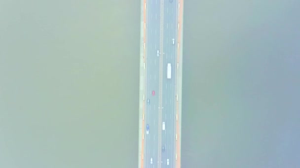 Letecký výhled. most v paprscích slunečného rána. Podzimní opar ve vzduchu, auta jedou přes most. Zataženo. — Stock video