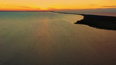 Hava görüntüsü. Güzel bulutların arkasında mavi denizde sörf yapan uçurtma. Gün batımı