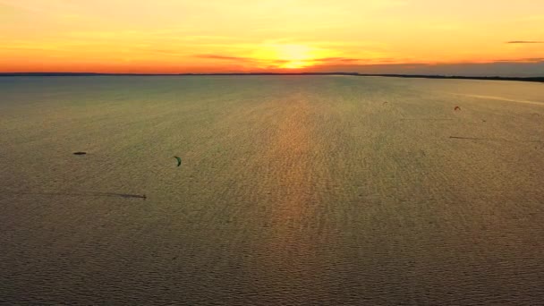 Luftaufnahme. Kitesurfen auf dem blauen Meer im Hintergrund der schönen Wolken. Sonnenuntergang — Stockvideo