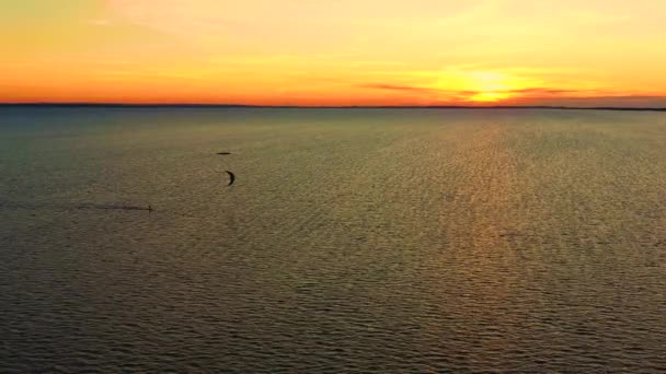 Vista aérea. Cometa surfeando en el mar azul en el fondo de hermosas nubes. Puesta de sol — Vídeos de Stock